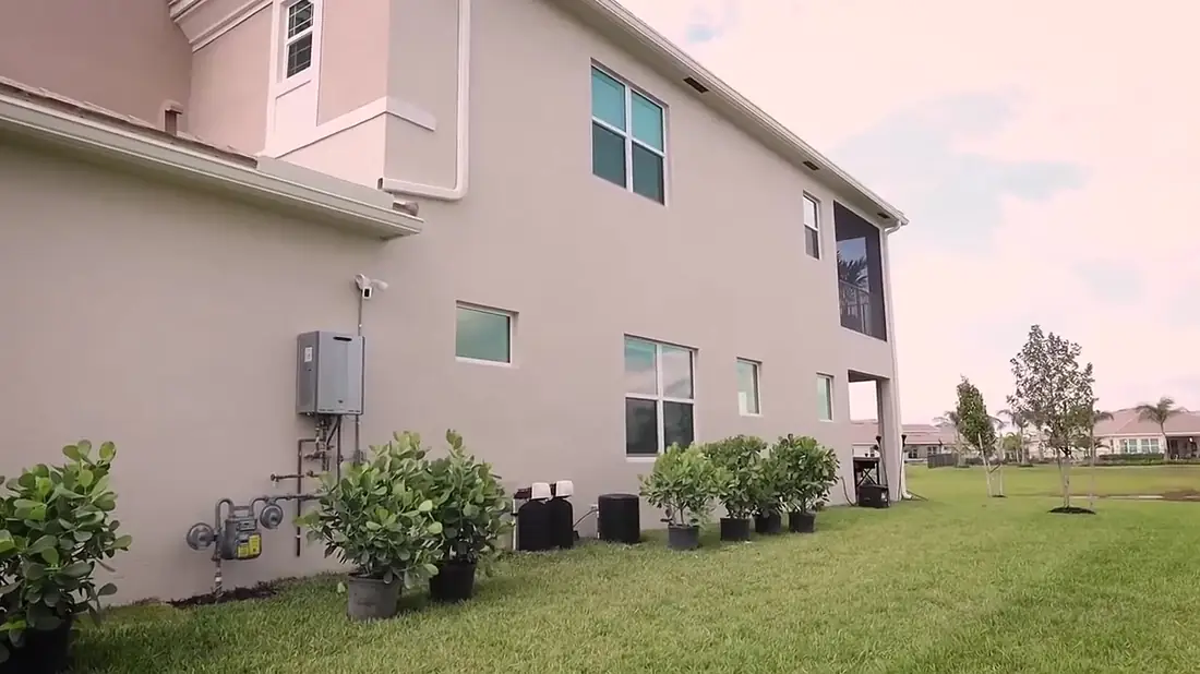 Two-story Palm Beach County home with Simple Water Service whole-home system installed along the side wall